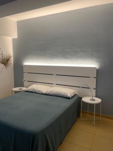 1 dormitorio con 1 cama grande y 2 mesas en B&B Dalla Nonna, en Mattinata