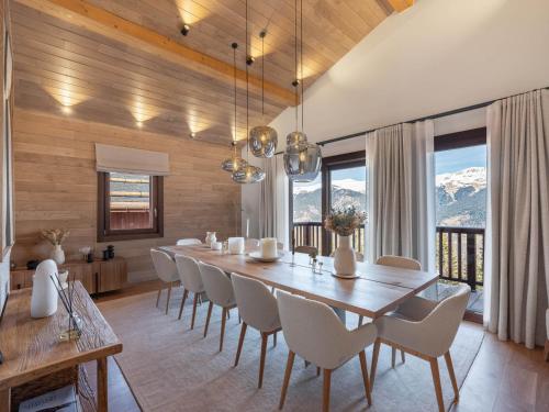 une salle à manger avec une grande table et des chaises en bois dans l'établissement Chalet Luxueux avec Jacuzzi Intérieur à 400m des Pistes - FR-1-563-141, à Courchevel