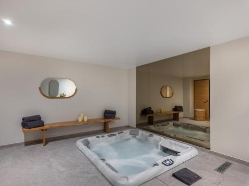 - une baignoire dans une chambre avec un grand miroir dans l'établissement Chalet Luxueux avec Jacuzzi Intérieur à 400m des Pistes - FR-1-563-141, à Courchevel