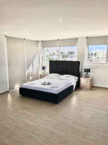 a bedroom with a large bed in a room with windows at Bright Top Floor Studio-Apartment in Kalamaki in Athens