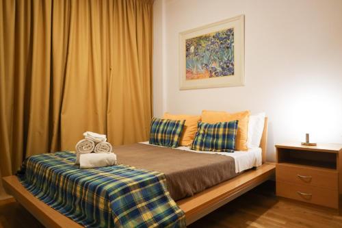 - une chambre avec un lit doté d'oreillers jaunes et bleus dans l'établissement Apartamentos da Orada T2-F 010 Marina de Albufeira, à Páteo