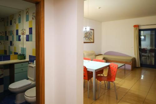 une chambre avec une table et des chaises et une salle de bains. dans l'établissement Apartamentos da Orada T2-F 010 Marina de Albufeira, à Páteo