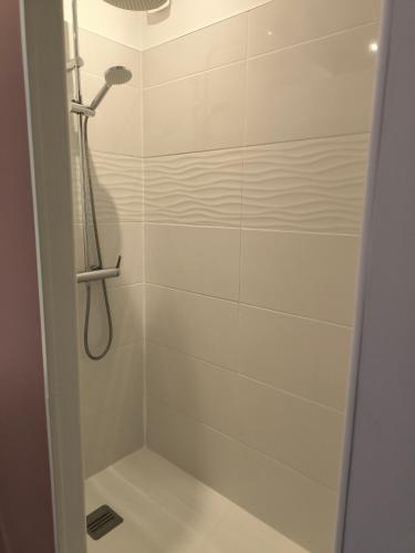 une douche avec pommeau de douche dans une salle de bain dans l'établissement La P'tite Maison, à Coulanges
