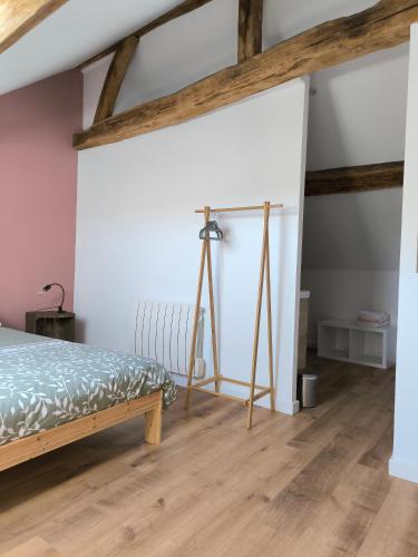 - une chambre avec un lit et un tripode dans l'établissement La P'tite Maison, à Coulanges