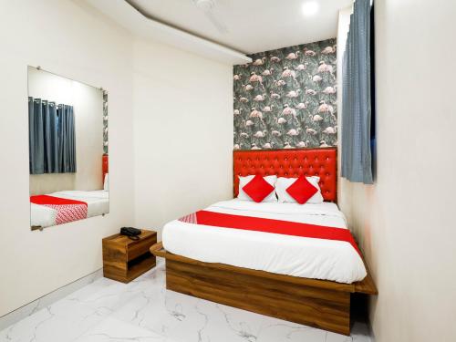 Hotel King Residency في مومباي: غرفة نوم مع سرير مع اللوح الأمامي الأحمر