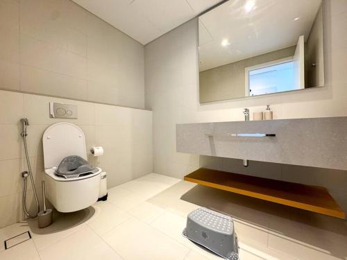 a bathroom with a toilet and a sink and a mirror at Fantastic and Rare 4BR+maid's in JBR Walk in Dubai