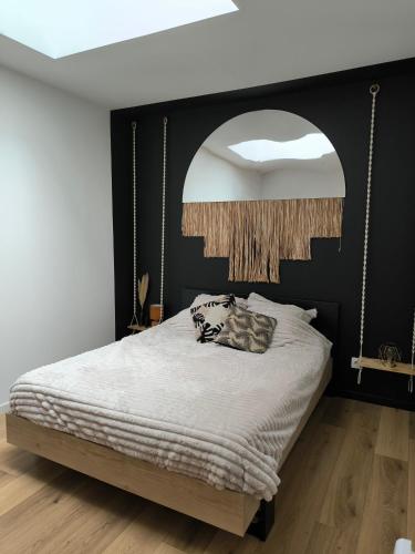 - une chambre avec un grand lit et une tête de lit noire dans l'établissement Le Cosy Loft, à Évreux