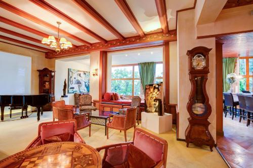 a living room with a grandfather clock and a piano at Hotel Regina in Wengen
