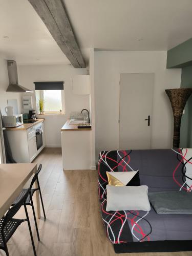 un salon avec un canapé et une cuisine dans l'établissement La P'tite Maison, à Coulanges