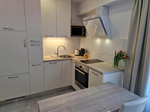 a small kitchen with white cabinets and a sink at Luxury apartment Galant 1 in Split