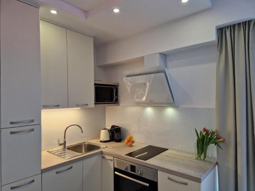 a small kitchen with white cabinets and a sink at Luxury apartment Galant 1 in Split