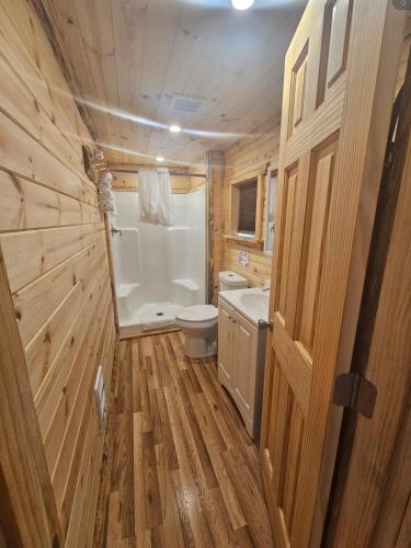 La salle de bains en bois est pourvue de toilettes et d'un lavabo. dans l'établissement Rimrock Lodge LLC, à Thompson Falls
