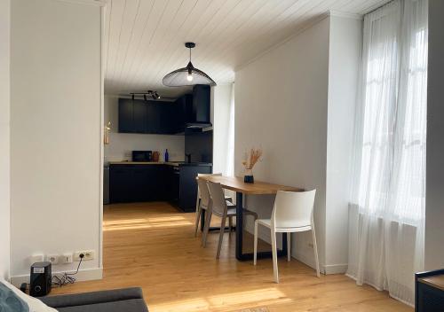 una cucina e una sala da pranzo con tavolo e sedie di Charmant appartement rénové au cœur de Concarneau a Concarneau