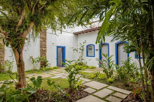 a building with blue doors and trees at Pousada Literária de Paraty in Paraty