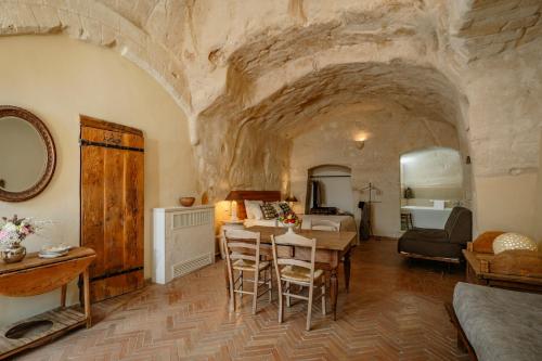 a bedroom with a room with a stone wall at Locanda Di San Martino Hotel & Thermae Romanae in Matera