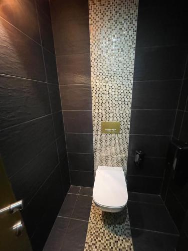 a bathroom with a white toilet in a shower at 33 Hostel in Baleal