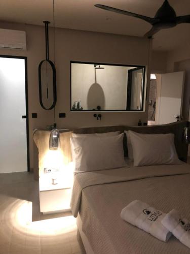 a bedroom with a bed with a mirror on the wall at Lithos Luxury Villa in Archangelos
