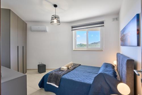 Un dormitorio con una cama azul y una ventana en Bugibba Terraced New 2 Bedroom 2 Bathroom, en St Paul's Bay
