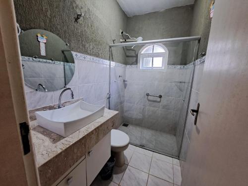 a bathroom with a sink and a shower and a toilet at Linda Casa 4 qts churrasqueira Prainha Mambucaba in Paraty