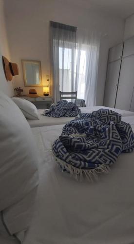 two beds with pillows on them in a bedroom at Alkisti's seaside apartments in Pythagoreio