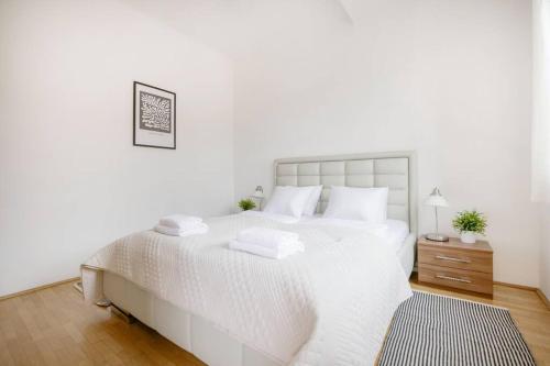 um quarto branco com uma cama branca e piso em madeira em Dream Home with Grand Terrace in the City Center em Budapeste