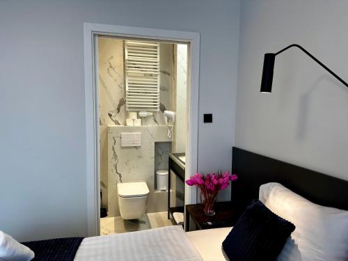 sypialnia z łóżkiem oraz łazienka z toaletą w obiekcie Motława Riverside Apartments w Gdańsku