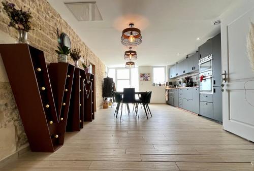 a kitchen with blue cabinets and a table and chairs at Maison en pierre avec jacuzzi in Caen