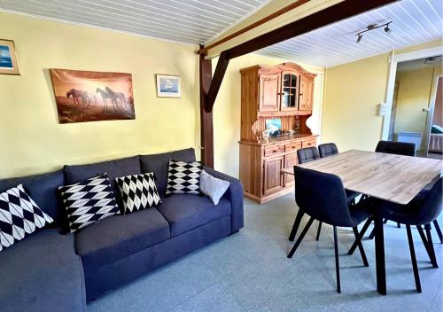 - un salon avec un canapé bleu et une table dans l'établissement Chalet au Lac de Maguide, à Biscarrosse