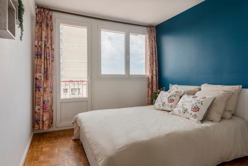 Schlafzimmer mit blauen Wänden und einem Bett mit Kissen in der Unterkunft Bourg la reine cozy spacing apartment in Bourg-la-Reine