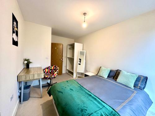 a bedroom with a bed and a desk and a table at Peaceful shared flat 30mins Central London in Colindale
