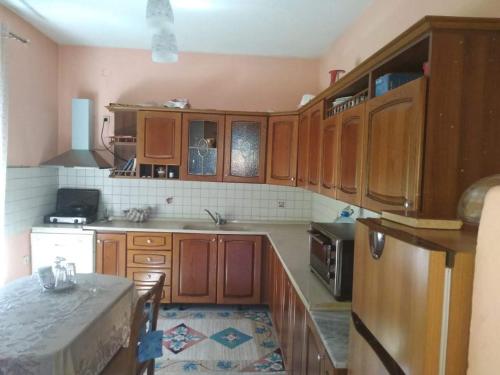 uma cozinha com armários de madeira e uma bancada em Villa Green House em Shkodër