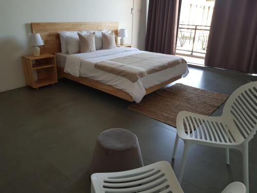 a bedroom with a bed and a chair and a window at Villas Rocher - Standard Suite 2B in Grand Baie
