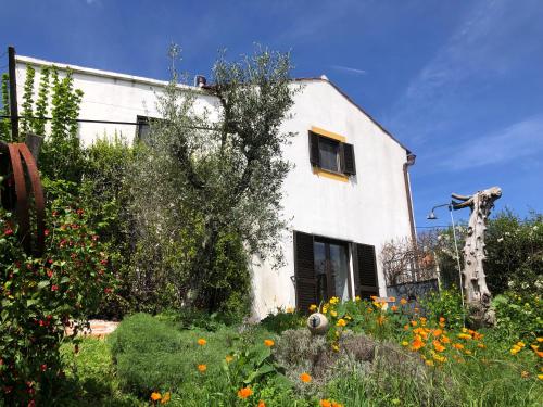 una casa blanca con un jardín con flores delante en House Of The Three Marias, en Pedrógão Grande