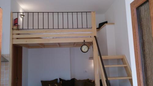 a loft bed in a room with a clock at Apartment Studio Prima in Rijeka