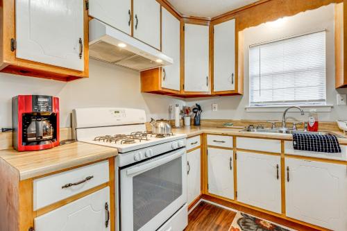 a kitchen with white appliances and wooden cabinets at Charming Satsuma Home about 14 Mi to Mobile! in Saraland