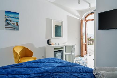 1 dormitorio con 1 cama, 1 silla y TV en Villa Prota, en Vico Equense