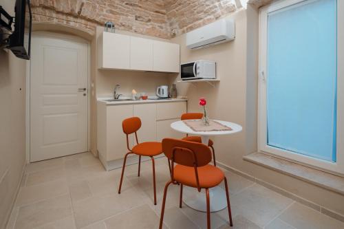 eine Küche mit einem Tisch und Stühlen sowie einem Fenster in der Unterkunft La Maison di Daniela in Terlizzi