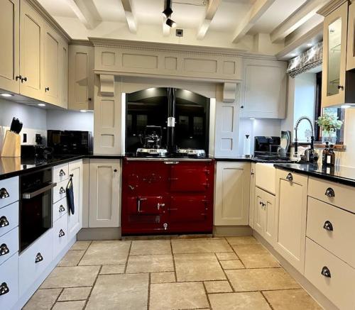 a large kitchen with white cabinets and a red drawer at The Wain House - A luxury countryside home for 6-8 near Ludlow in Ashford Carbonell