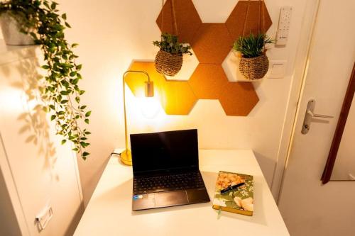 einen Laptop auf einem Schreibtisch mit einem Buch in der Unterkunft AZUR COZY- 1 CHAMBRE 3 PERSONNES RENOVE- GARE ST CHARLES/JOLIETTE in Marseille