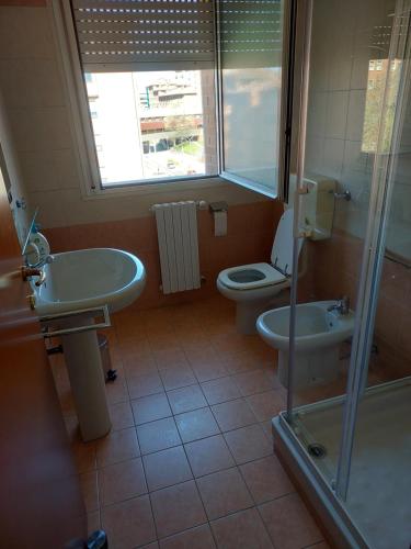 La salle de bains est pourvue de toilettes, d'un lavabo et d'une douche. dans l'établissement HOUSE FIERA, à Bologne