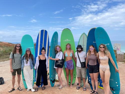 a group of women standing in front of surfboards at 33 Hostel in Baleal