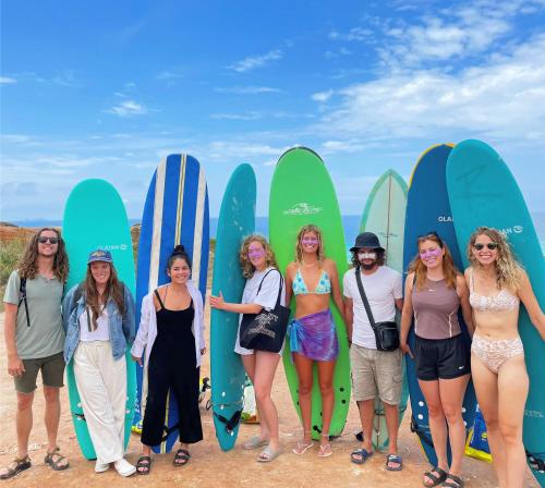 a group of women standing in front of surfboards at 33 Hostel in Baleal