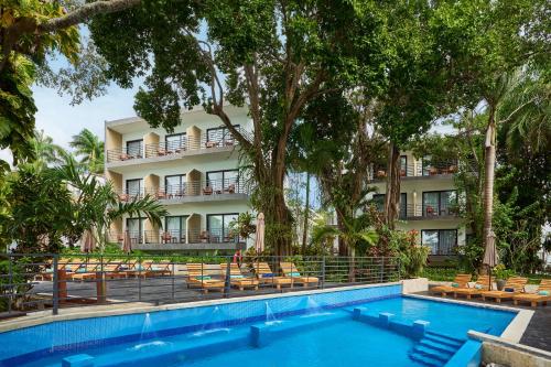 a hotel with a swimming pool in front of a building at Cristalino Lagoon Front Hotel, Restaurant & Spa in Bacalar