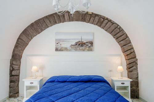 a bedroom with a blue bed and two white tables at Villa Prota in Vico Equense