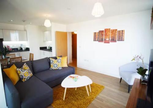 sala de estar con sofá azul y mesa en Excel - O2 Arena - 2 Bed Apartment Parking & Netflix, en Londres