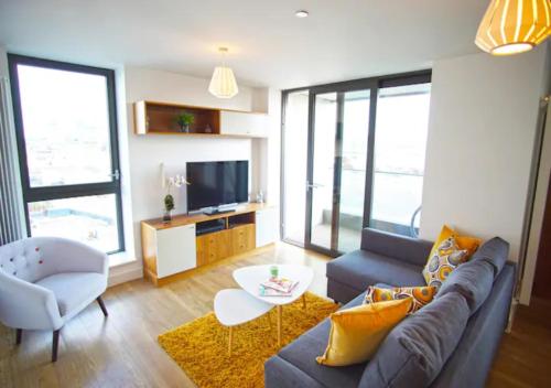ein Wohnzimmer mit einem Sofa und einem TV in der Unterkunft Excel - O2 Arena - 2 Bed Apartment Parking & Netflix in London