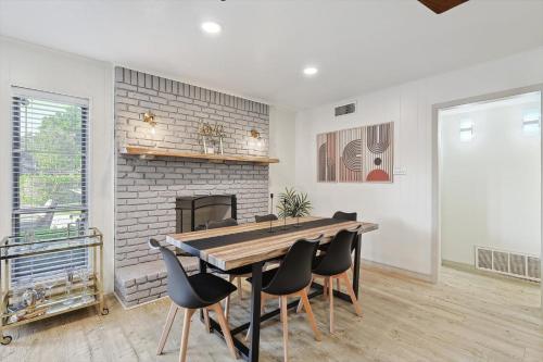 a dining room with a table and chairs and a fireplace at Spectacular 6BR 2,5BA Holiday Home with Pool in Dallas