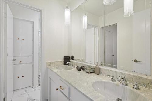 a bathroom with two sinks and a large mirror at Spectacular 6BR 2,5BA Holiday Home with Pool in Dallas