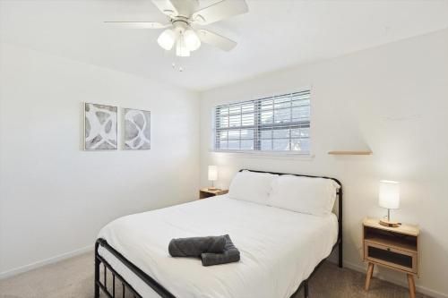 a white bedroom with a bed and a ceiling fan at Spectacular 6BR 2,5BA Holiday Home with Pool in Dallas