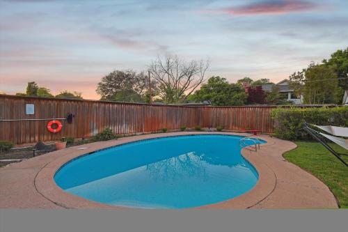 a swimming pool in a yard with a wooden fence at Spectacular 6BR 2,5BA Holiday Home with Pool in Dallas